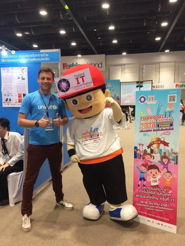 Me in a UNICEF t-shirt next to a mascot at an innovation fair in Bangkok, Thailand